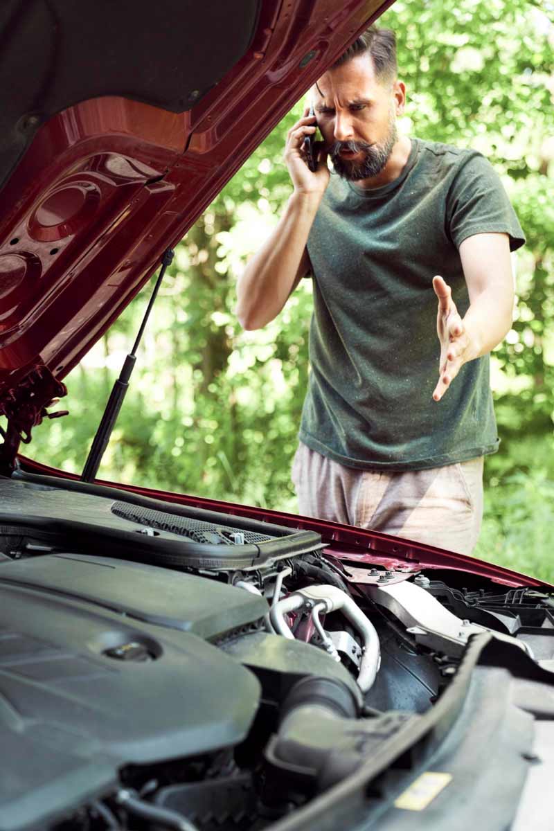 Junger Mann prüft Getriebeschaden bei Schrottauto Ankauf Bremen